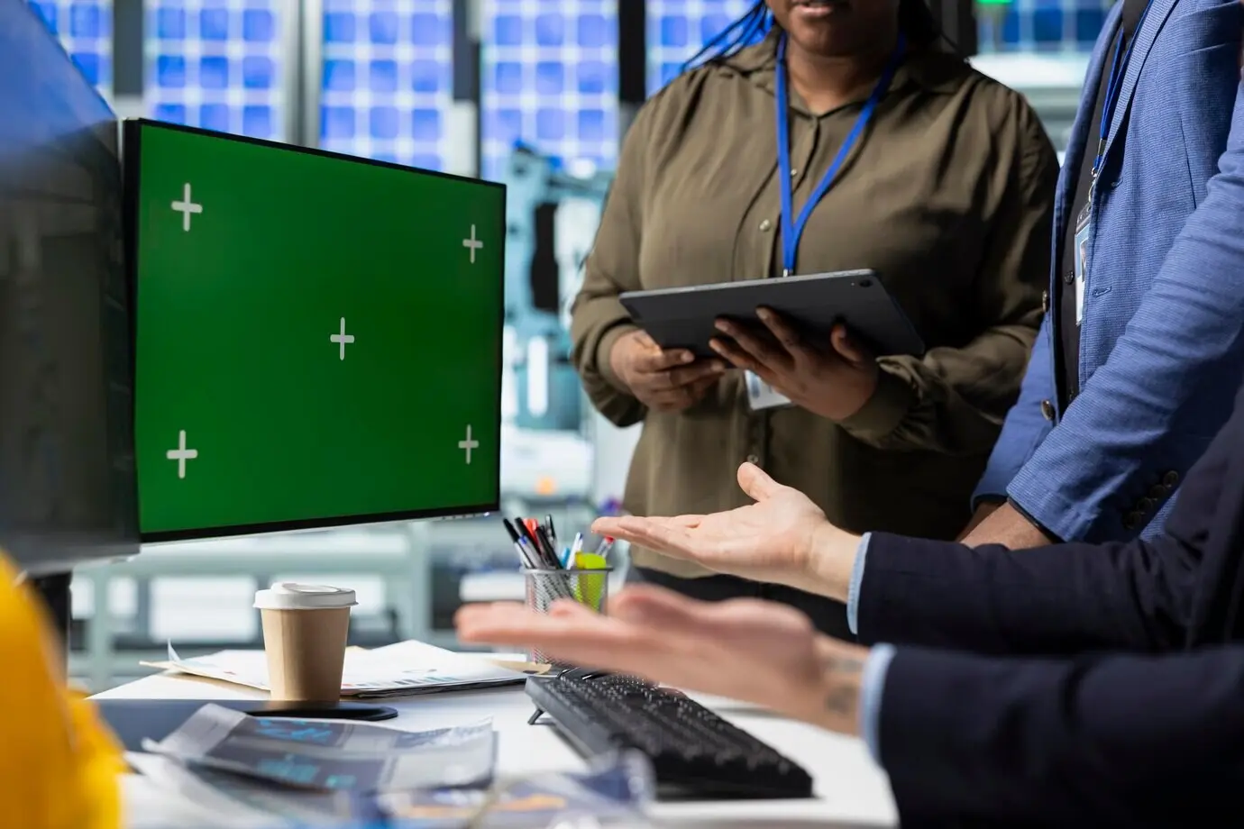 Коллеги проводят мозговой штурм решений у дисплея с макетом на солнечной электростанции.